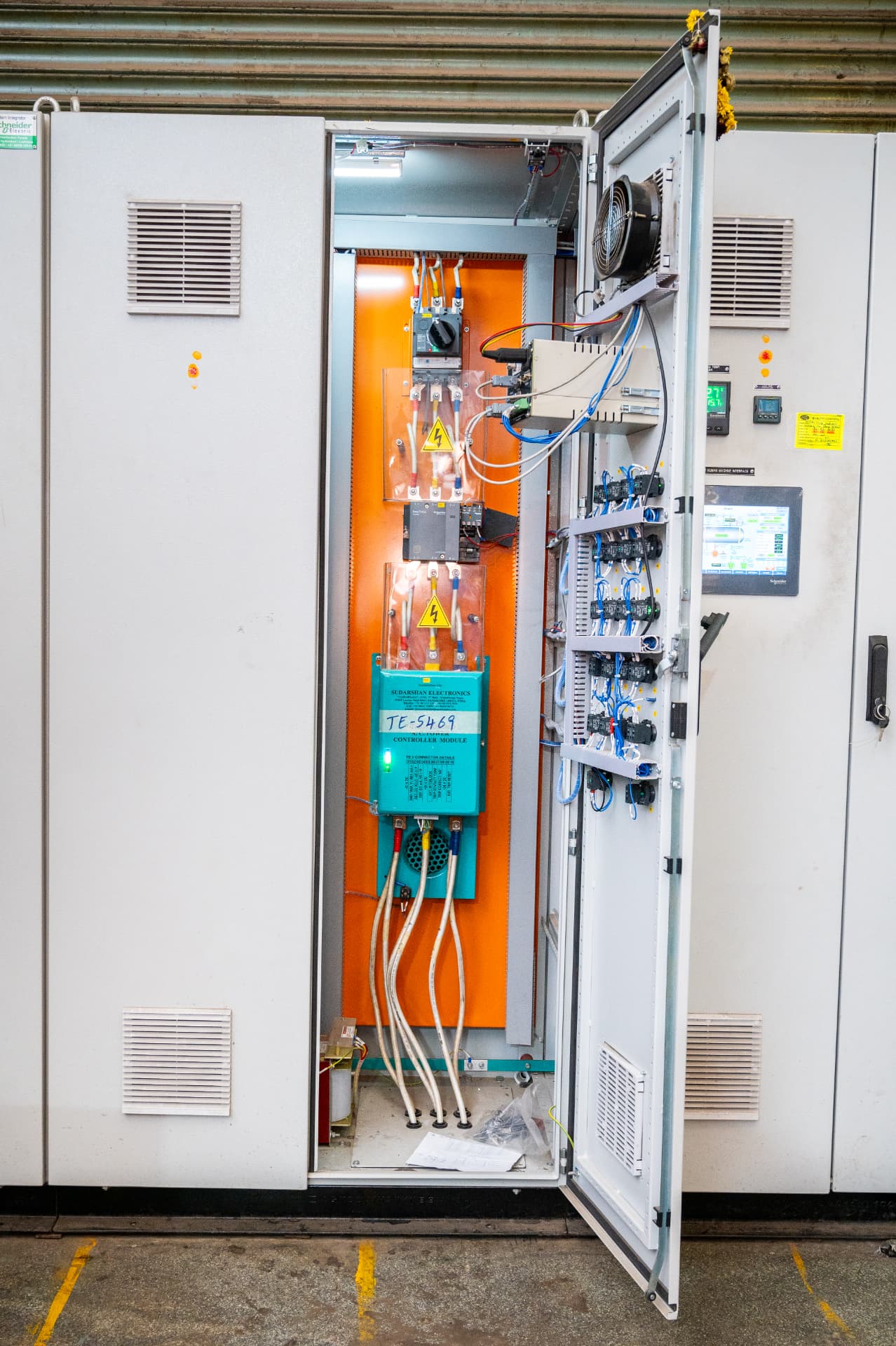 Tall industrial control cabinet with a Sudarshan Electronics AC power controller module and touchscreen furnace interface